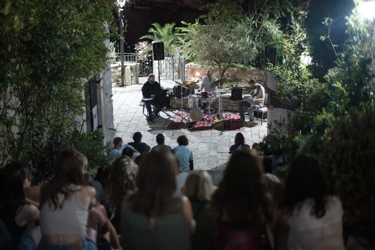 The evening programme in a garden, the audience on the ground and on chairs