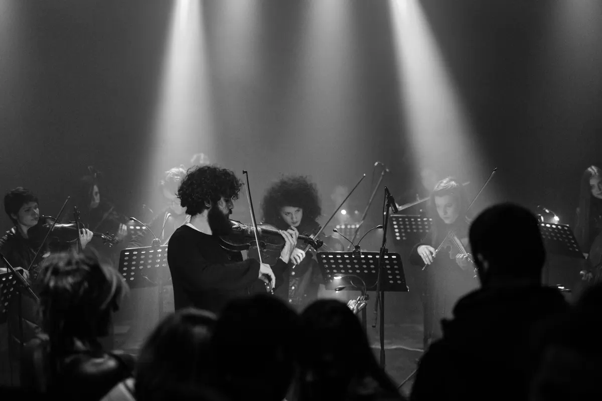 The orchestra’s violinists under stage lights at the Festival of Young Artists 24